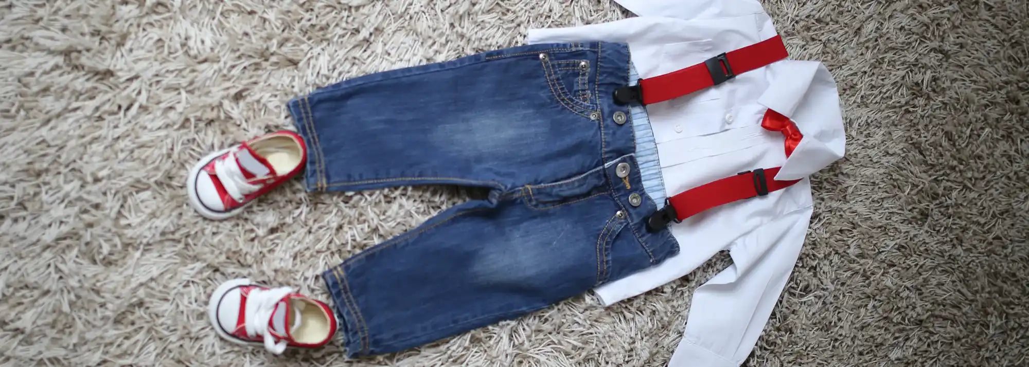 Roupa de criança com jeans, camiseta, suspensórios e sapatos.
